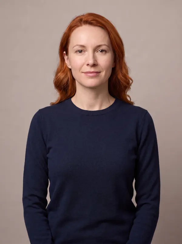 Woman with copper red hair wearing a navy crew-neck sweater