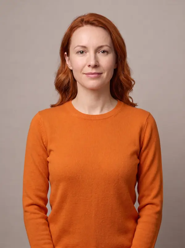 The same woman with copper red hair wearing a bright orange crew-neck sweater