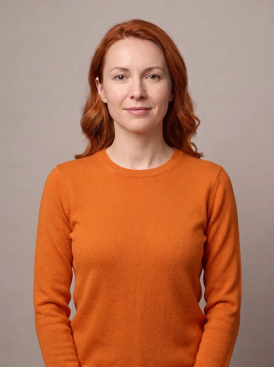 The same woman with copper red hair wearing a bright orange sweater