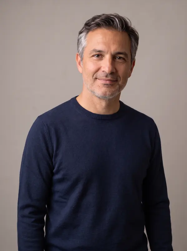 Man with salt-and-pepper hair wearing a navy crew-neck sweater